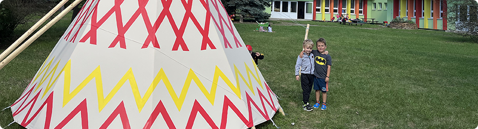 Foto dětí na zahradě školky vedle teepee